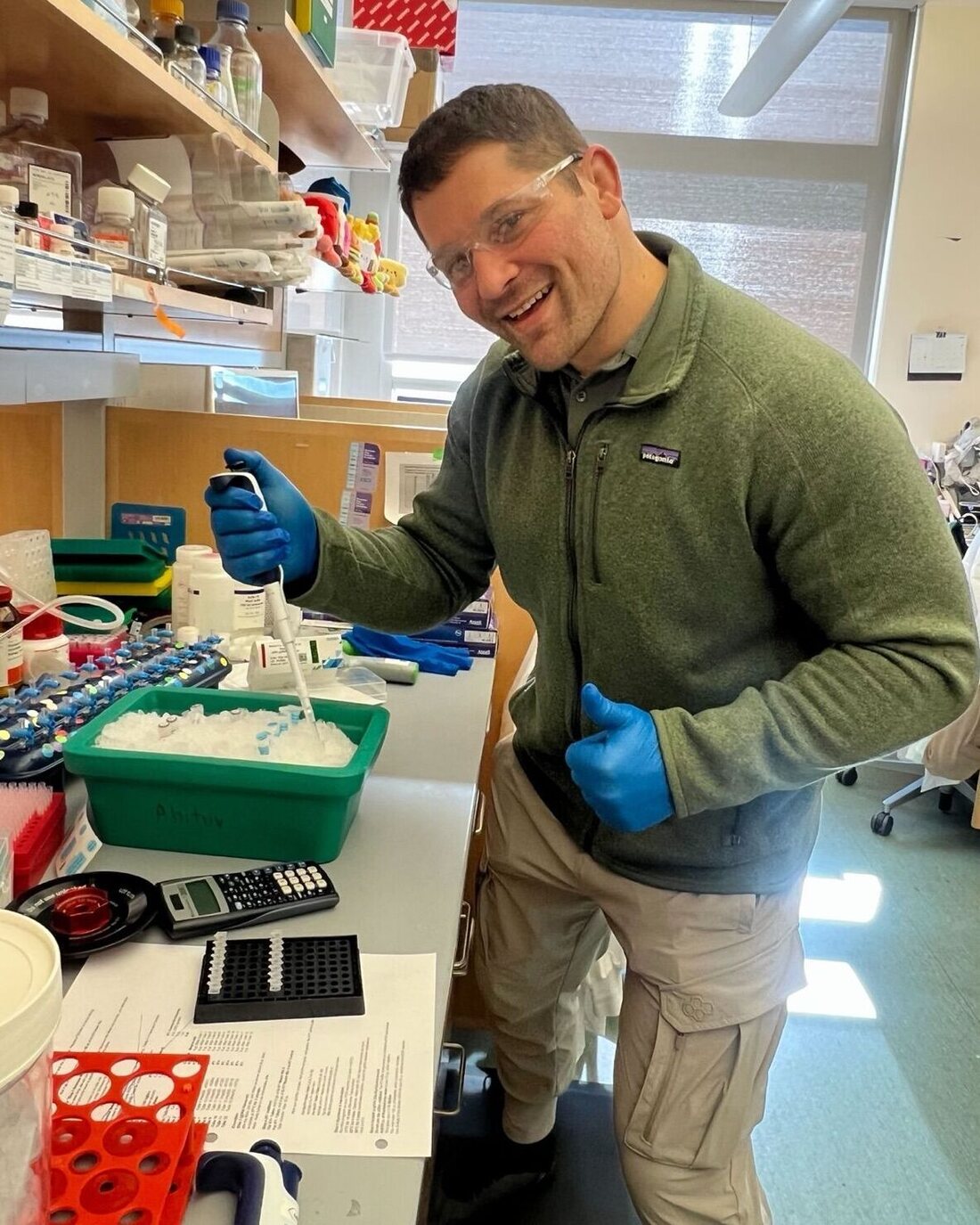 Orry Elor pipetting at the bench in the Ahituv Lab at UCSF, in safety glasses and gloves